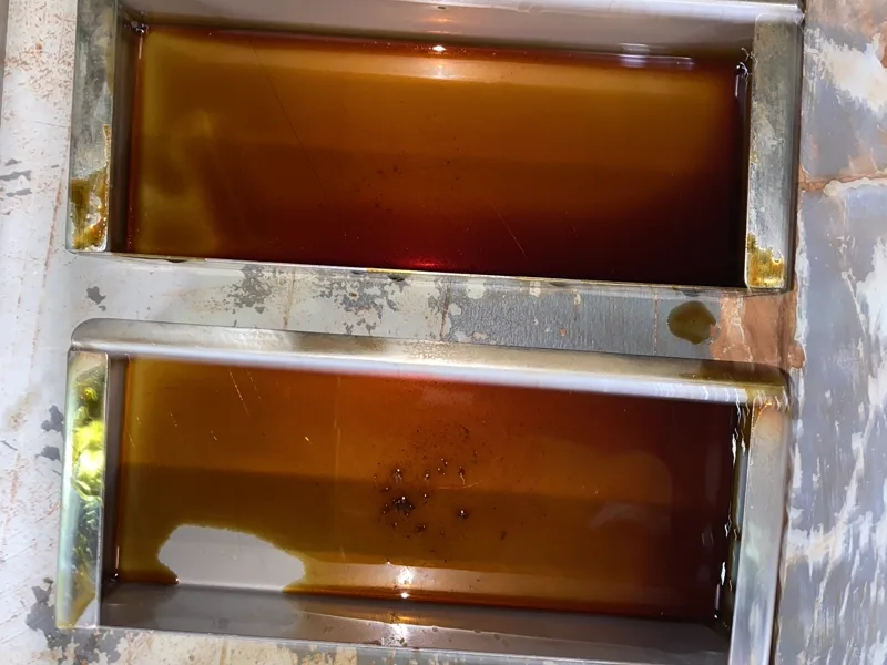 Canopy grease gutters holding a full load of amber grease before cleaning